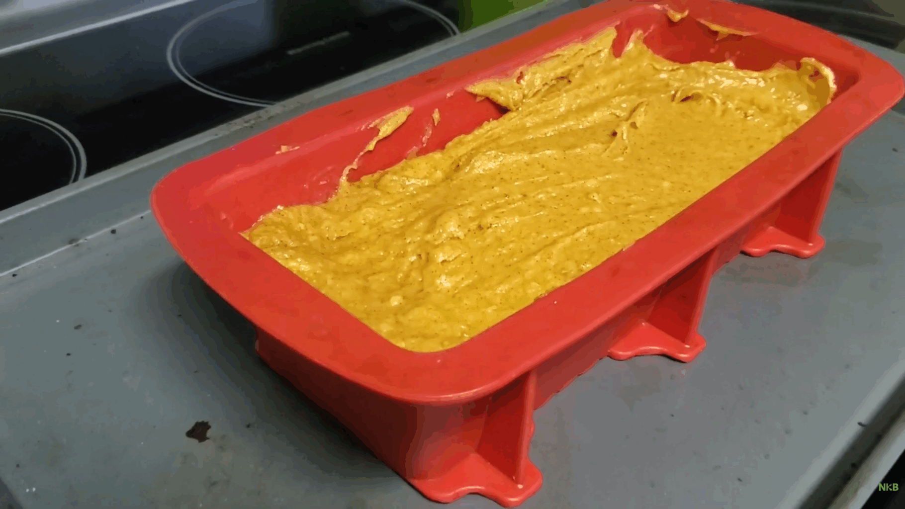 pumpkin bread batter in a red silicone mold