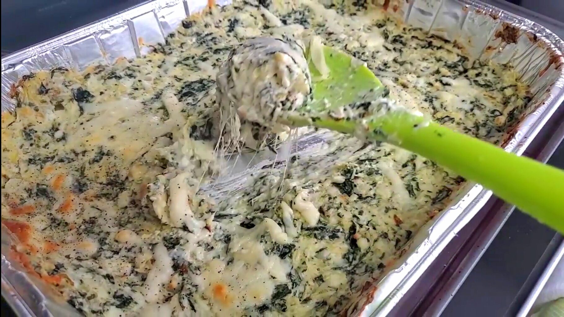 fresh baked spinach artichoke dip with a perfect cheese pull 